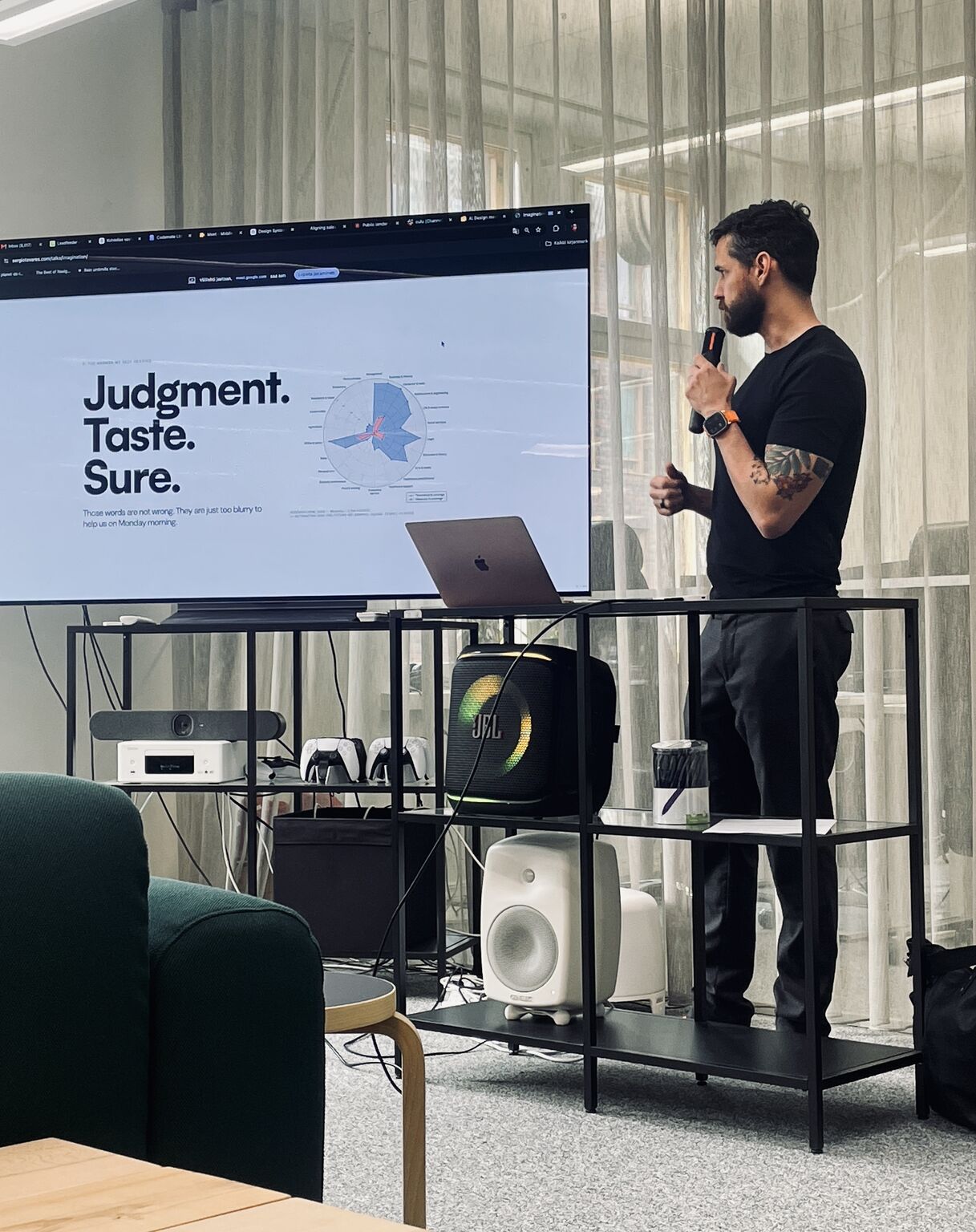 Sérgio Tavares presenting beside the “Judgment. Taste. Sure.” slide